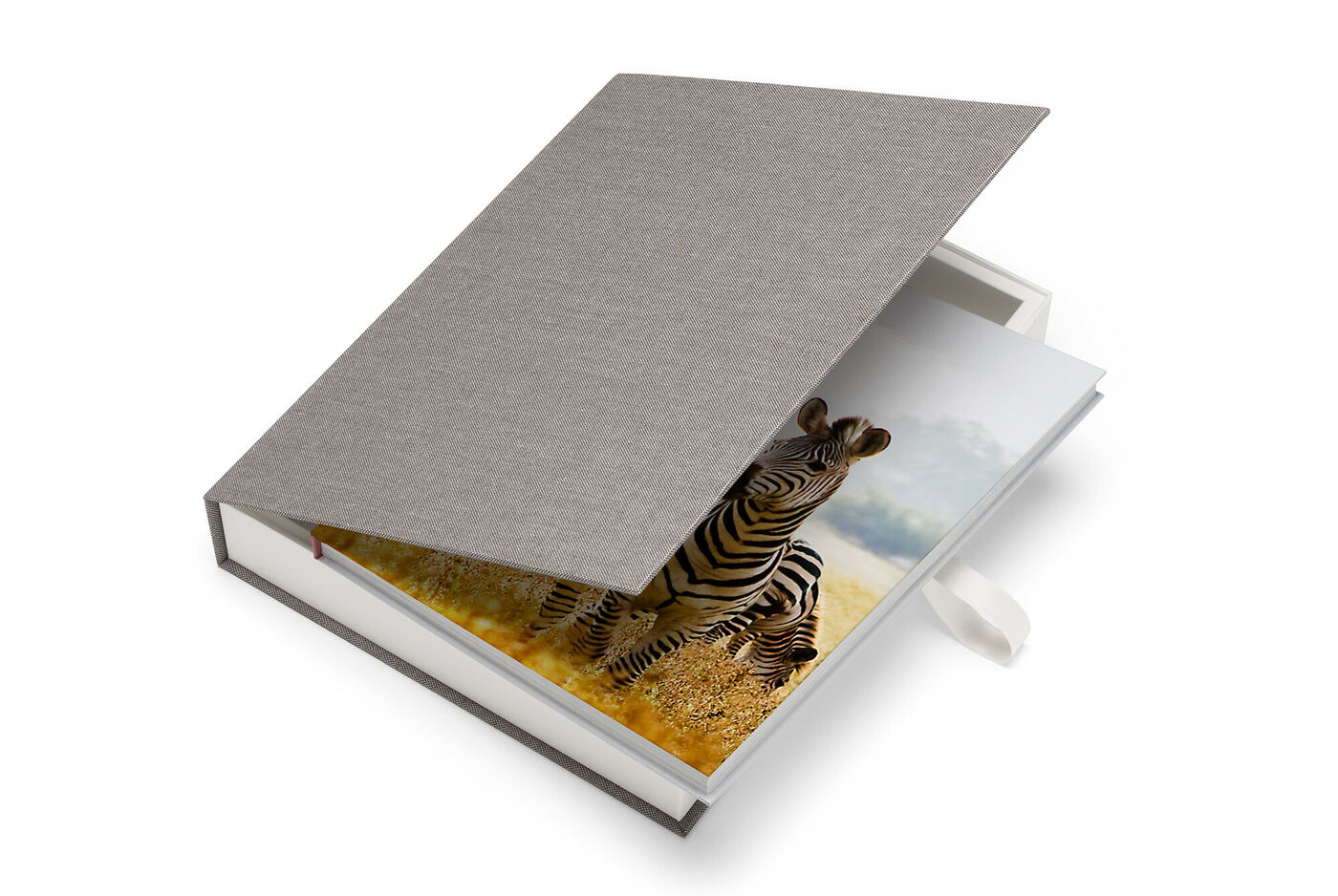 En åben CEWE-fotobog med en zebra på første side i et hyggeligt miljø.