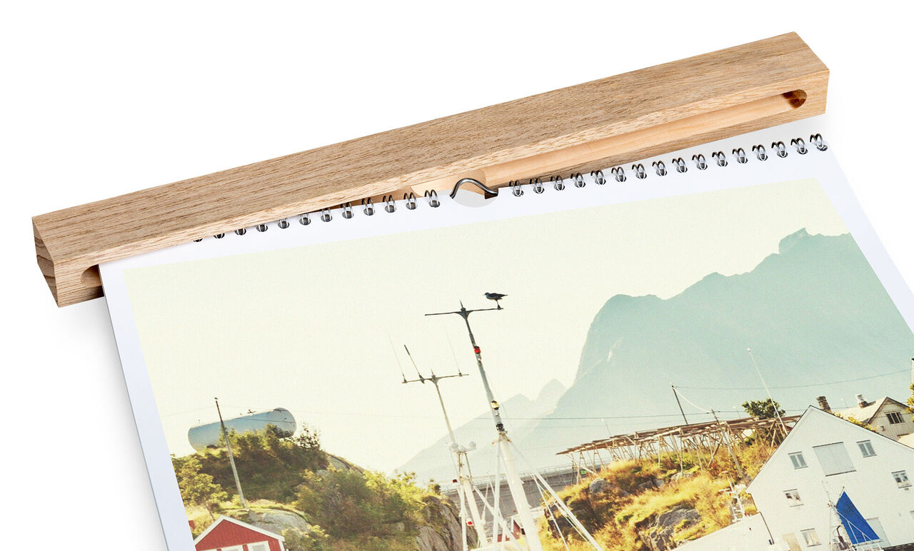 A CEWE photo calendar shows a picturesque coastal landscape with mountains visible in the background.