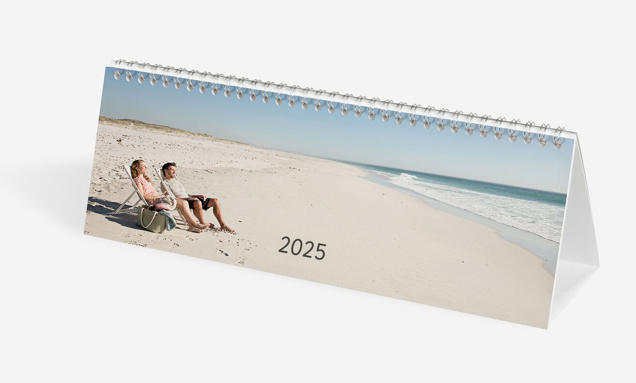 CEWE fotokalender med et par på stranden, der nyder solnedgangen i 2025