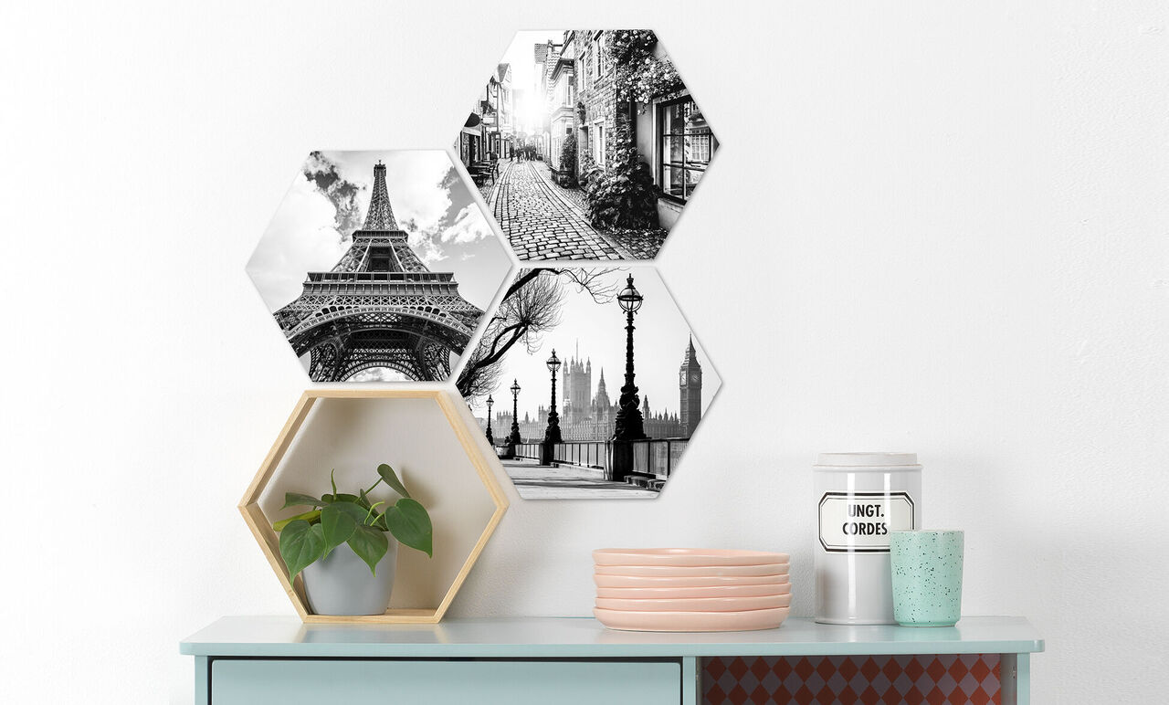 Tre hexagonale billeder i sort-hvid med seværdighederne Eiffeltårnet, Londons skyline og en gade.