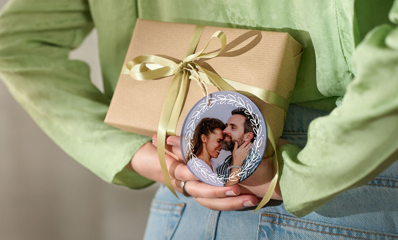 Gave med sløjfe og et rundt ornament med et billede.
