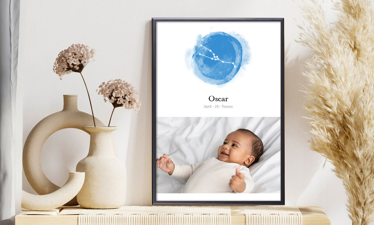 Et smukt vægbillede med navn og dato i blå akvarel med en glad baby i baggrunden.