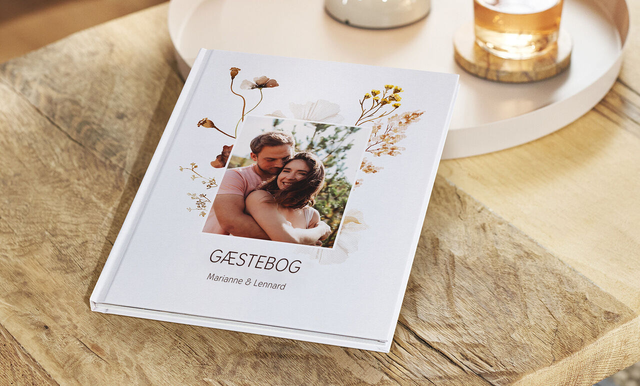 En smukt designet gæstebog med blomsterdekorationer.