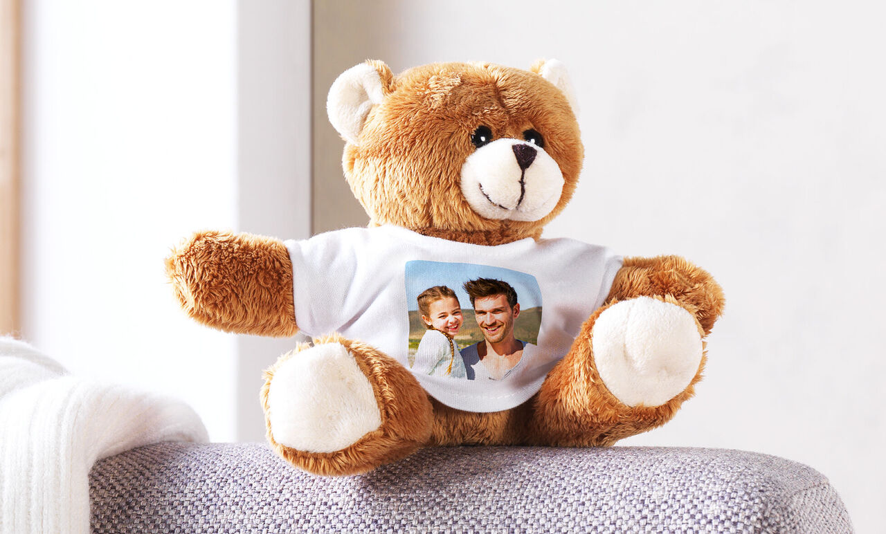 En fluffy bamse med en personaliseret T-shirt, hvor et foto ses.