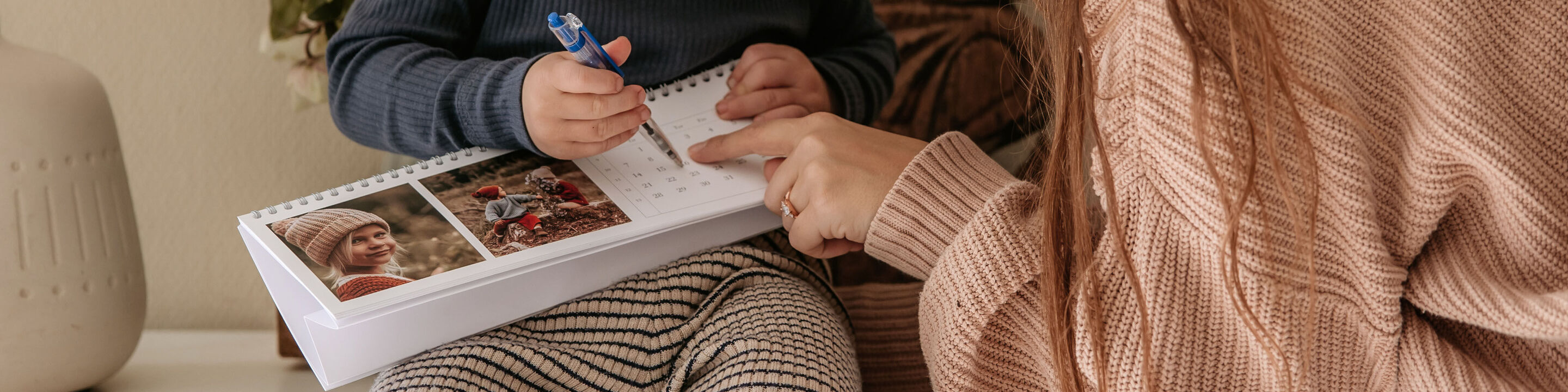 En mor viser sit barn en kalender med smukke billeder
