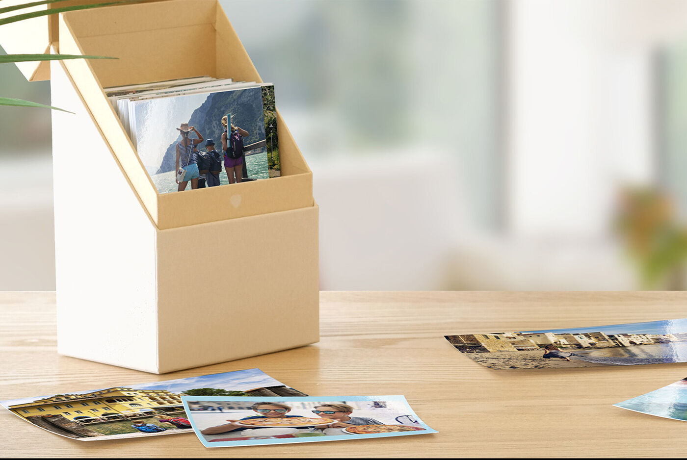 En dekorativ kasse med billeder og fotos spredt på bordet i forgrunden.
