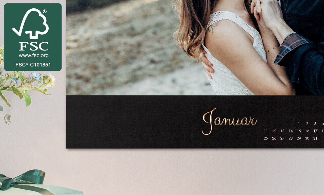 Kalender for januar med elegant design i sort og gylden skrift, viser et par i en kærlig omfavnelse