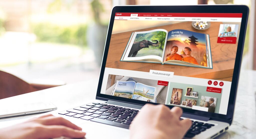 Nogen bladrer i en CEWE FOTOBOK på en laptop