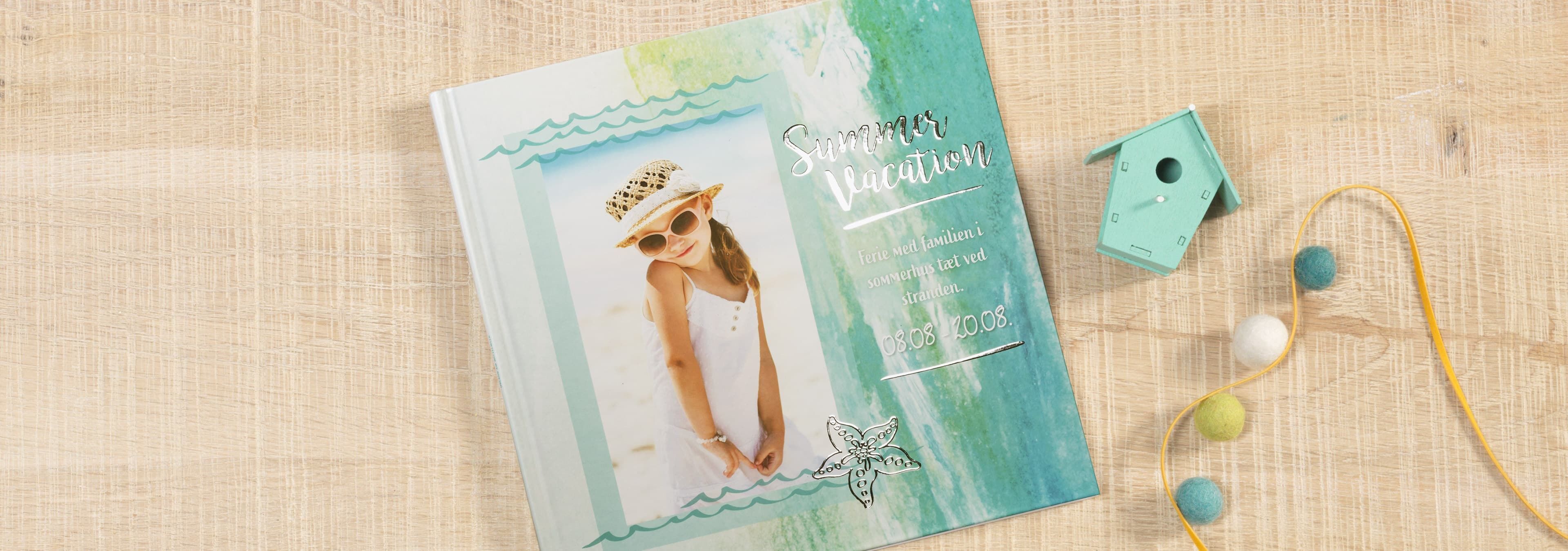 En smuk CEWE FOTOBOG med sommerligt cover-design og en kvinde i sommeroutfit.