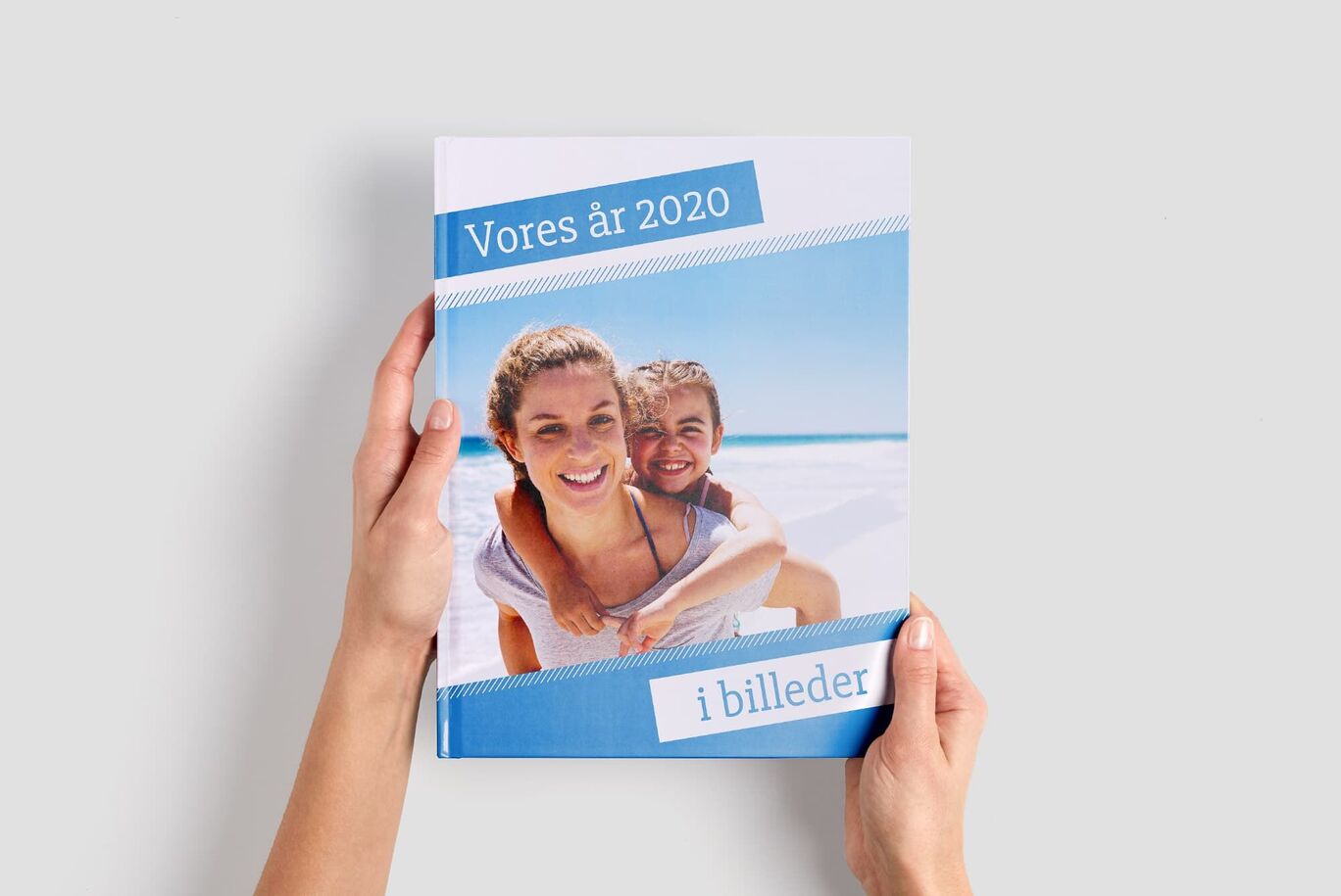 To børn nyder deres strandferie på forsiden af en CEWE fotobog.
