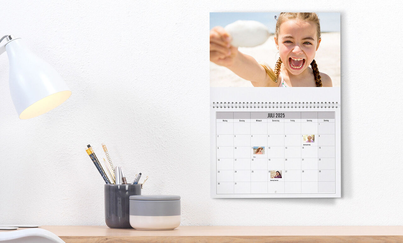 En personlig vægkalender med fotos og noter for juli 2023.
