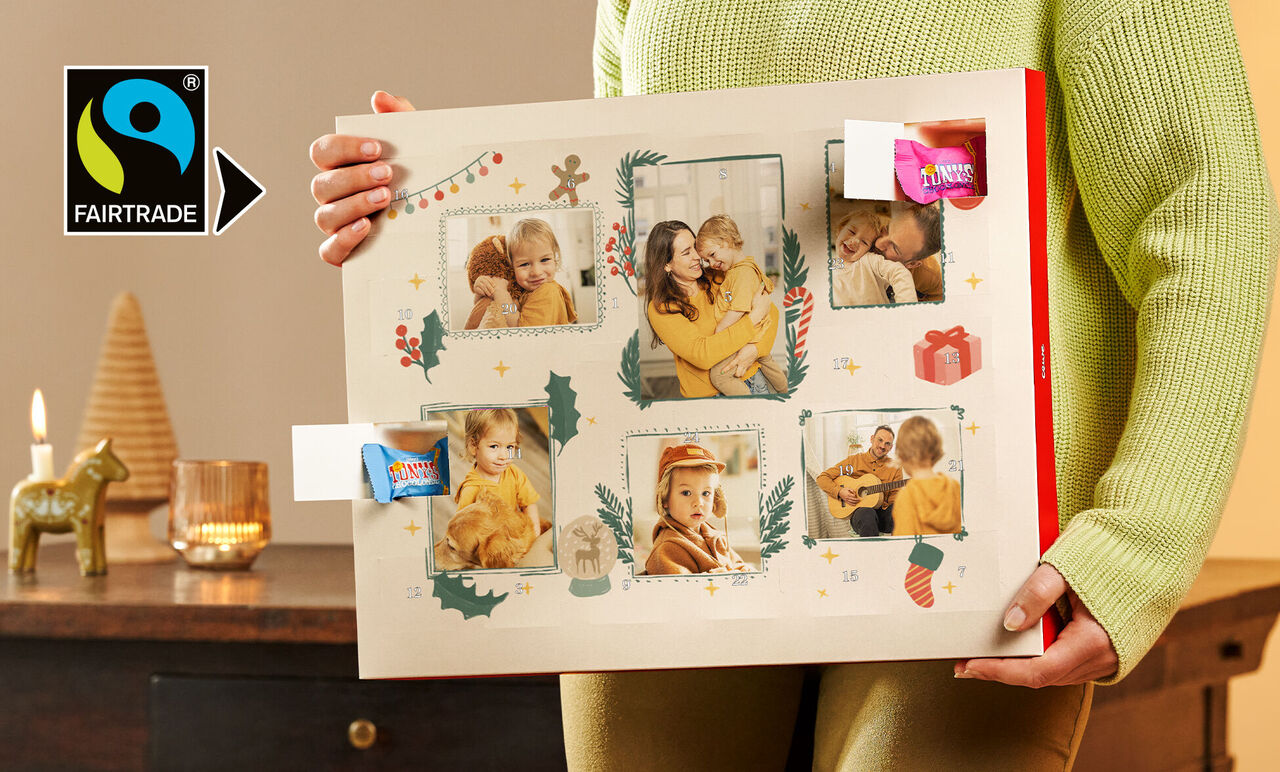 En person holder en smuk fotokalender med festlige billeder og dekoration.