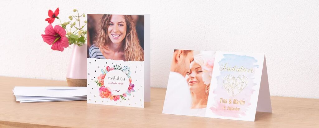 To designede kort med blomsterdesign på et bord.