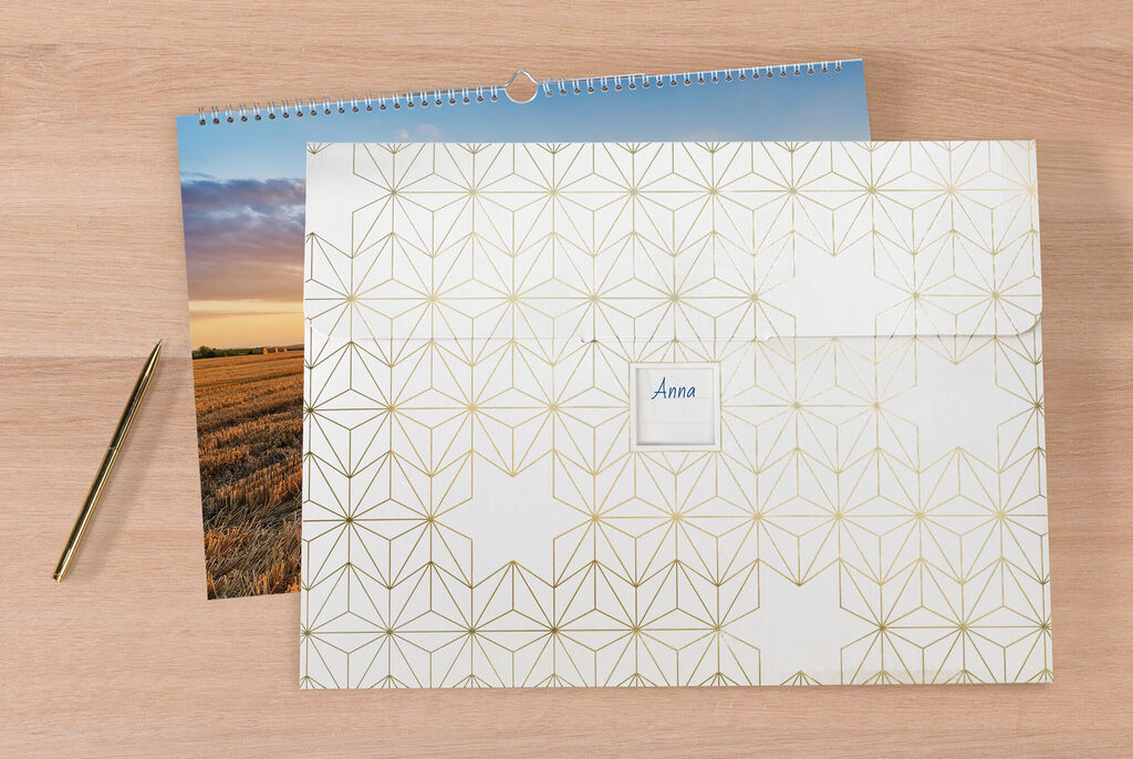 En stilfuld CEWE fotokalender med moderne, gyldent geometrisk design.