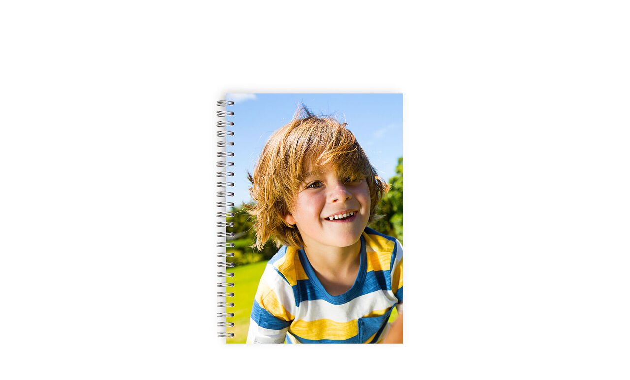 Glædeligt barn med en personlig notesbog i hånden, omgivet af natur.