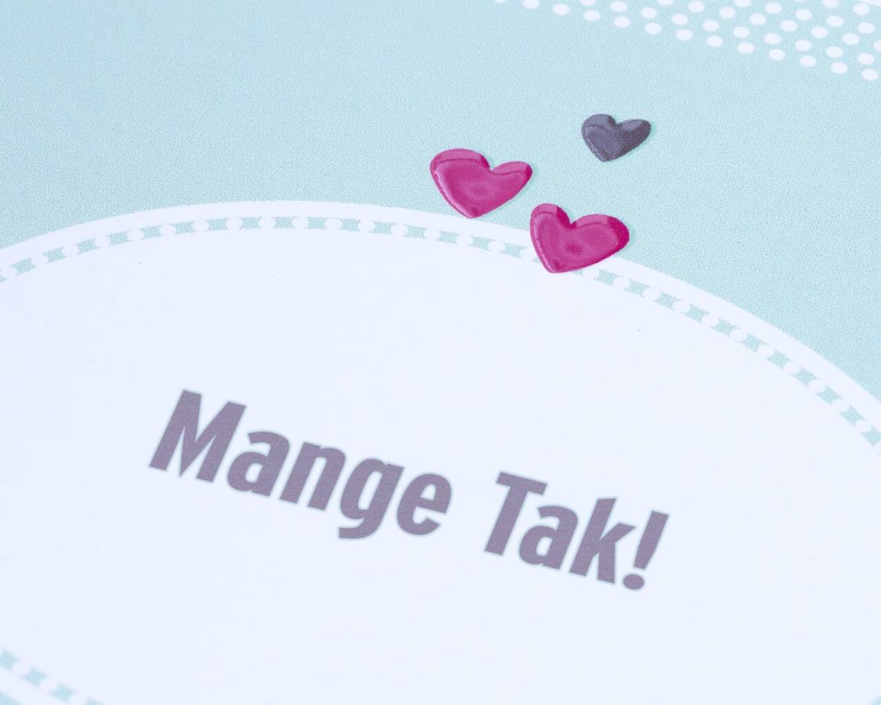 Kort med teksten 'Mange Tak!', dekoreret med farverige hjerter.