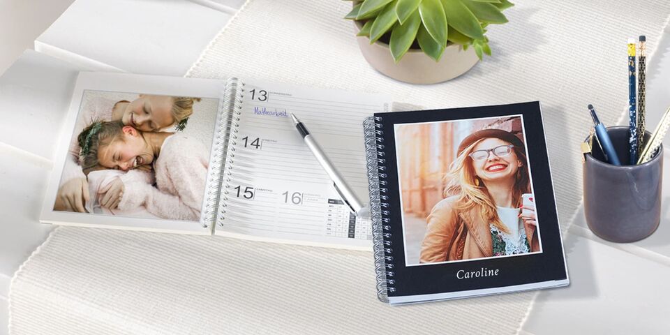 En kærligt designet fotokalender med personlige billeder og en minimalistisk notesbog på et bord