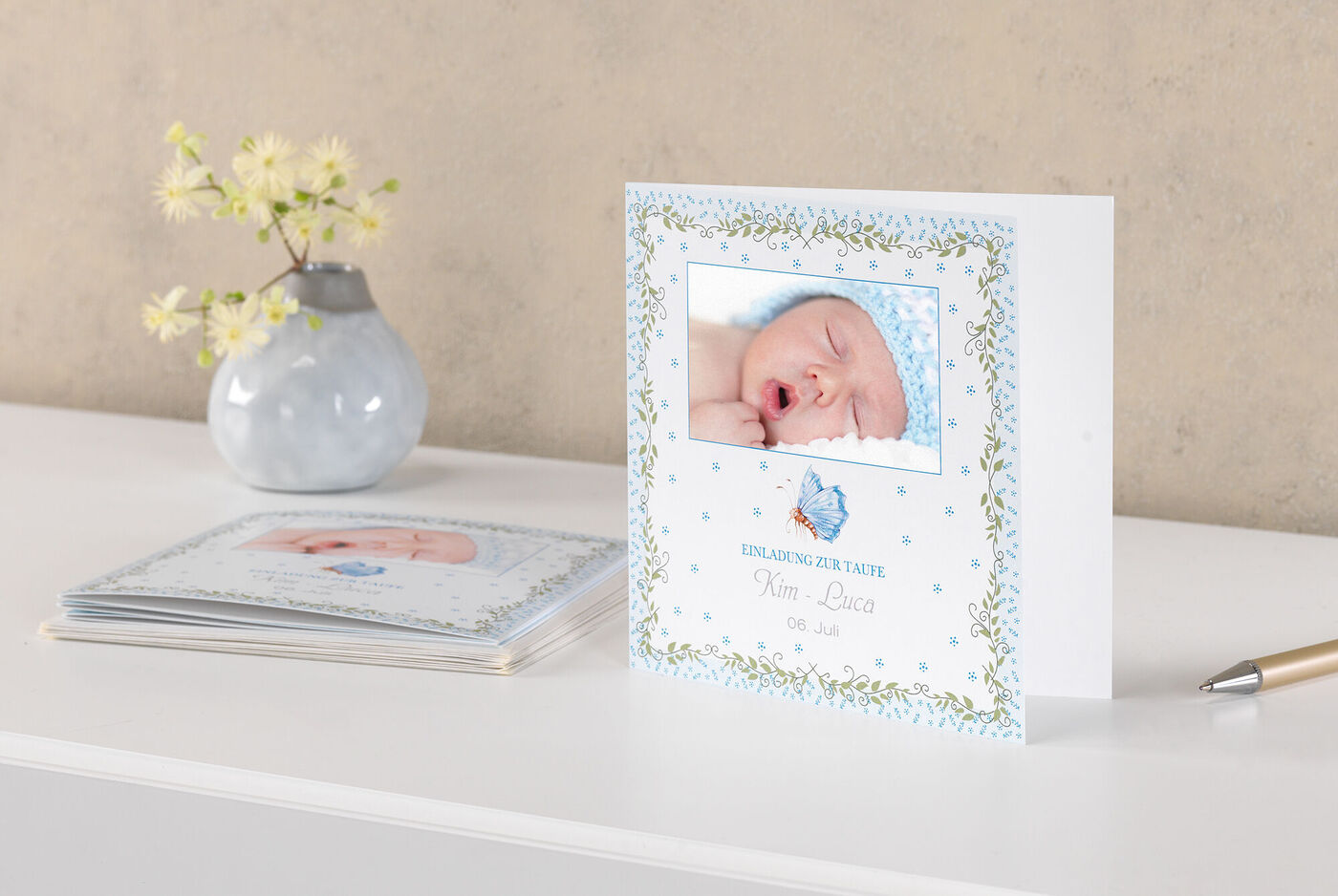 Et sødt kort til en babys fødsel med et blåt design og et sødt billede af den sovende nyfødte