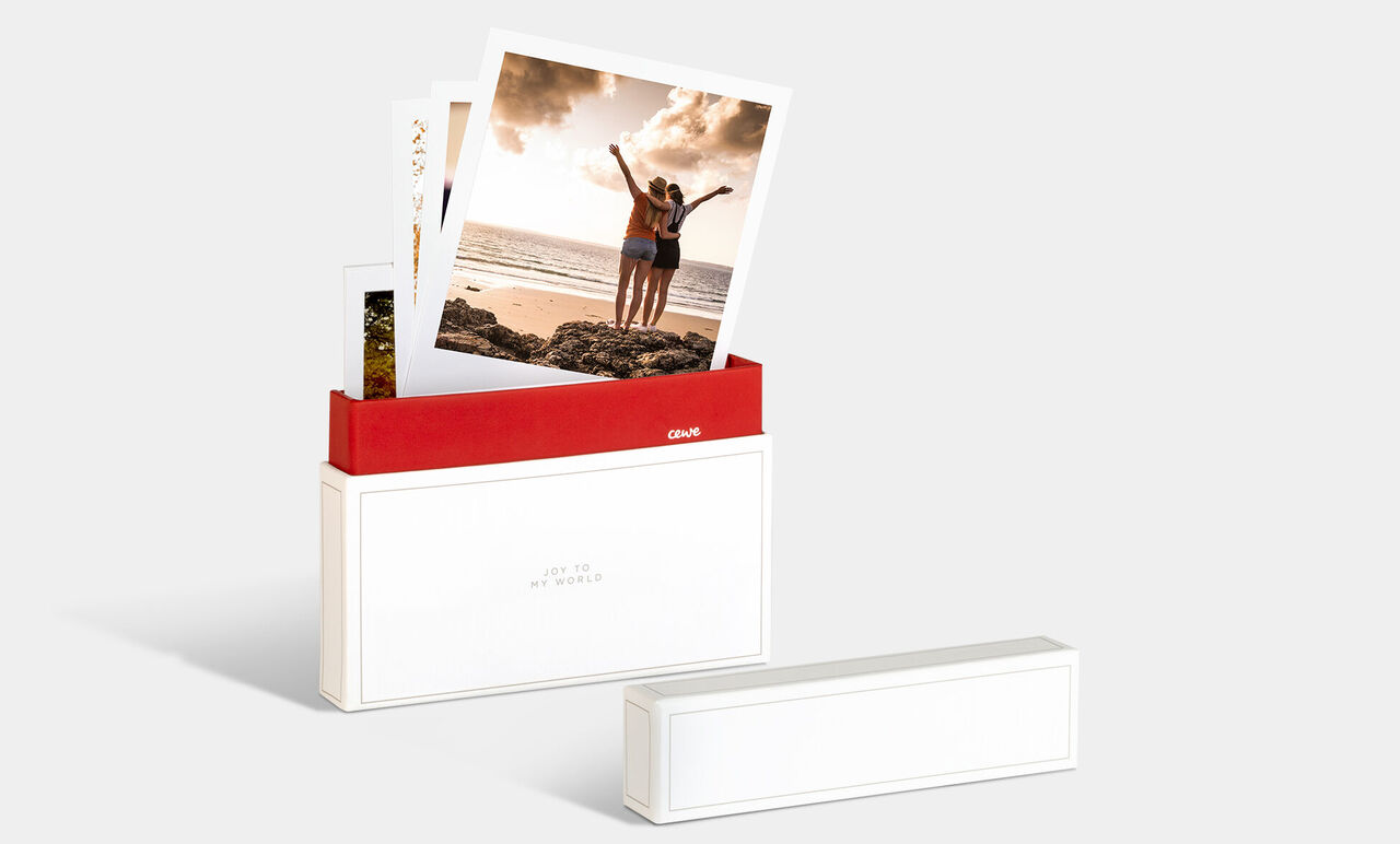 En CEWE fotoboks med billeder af to glade personer på stranden.