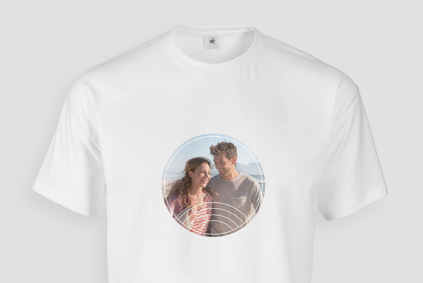 Et par i en hvid T-shirt med et rundt billede i ramme, der udstråler glæde.