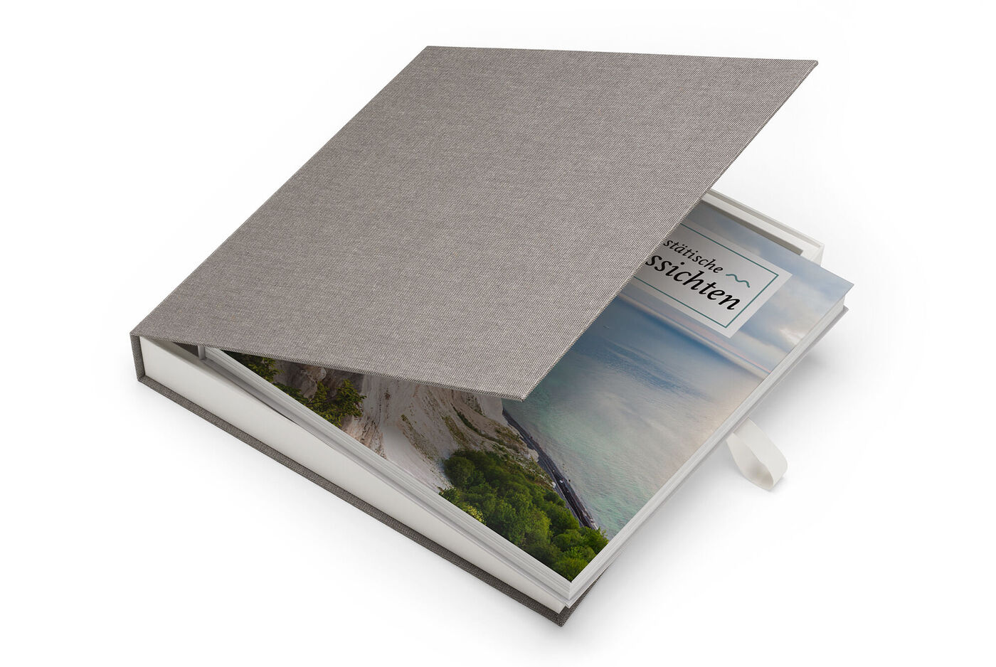 En stilfuld CEWE FOTOBOK med gråt stofomslag og vindue med et farverigt landskabsbillede.