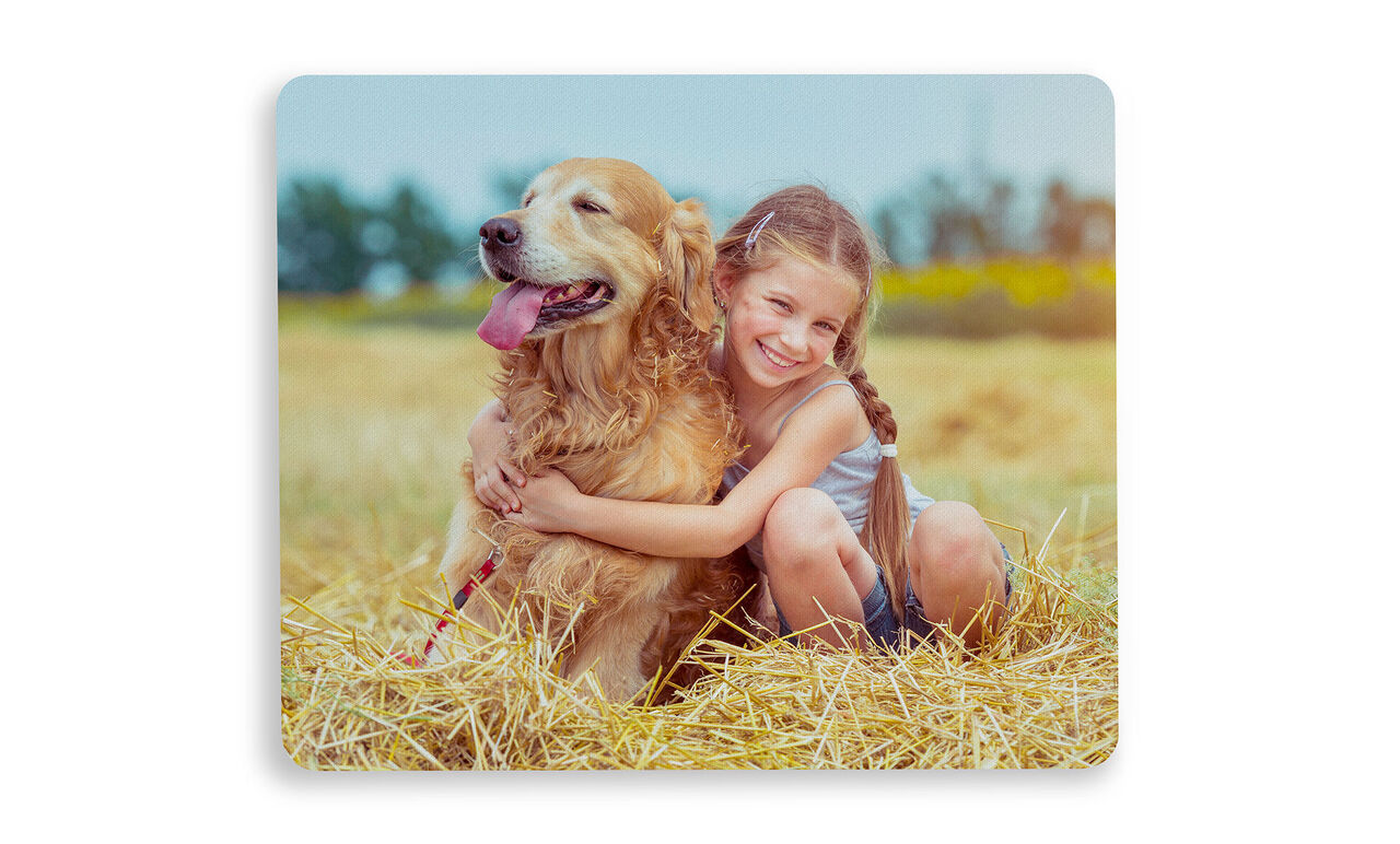 Et barn krammer en golden retriever på en smuk eng.