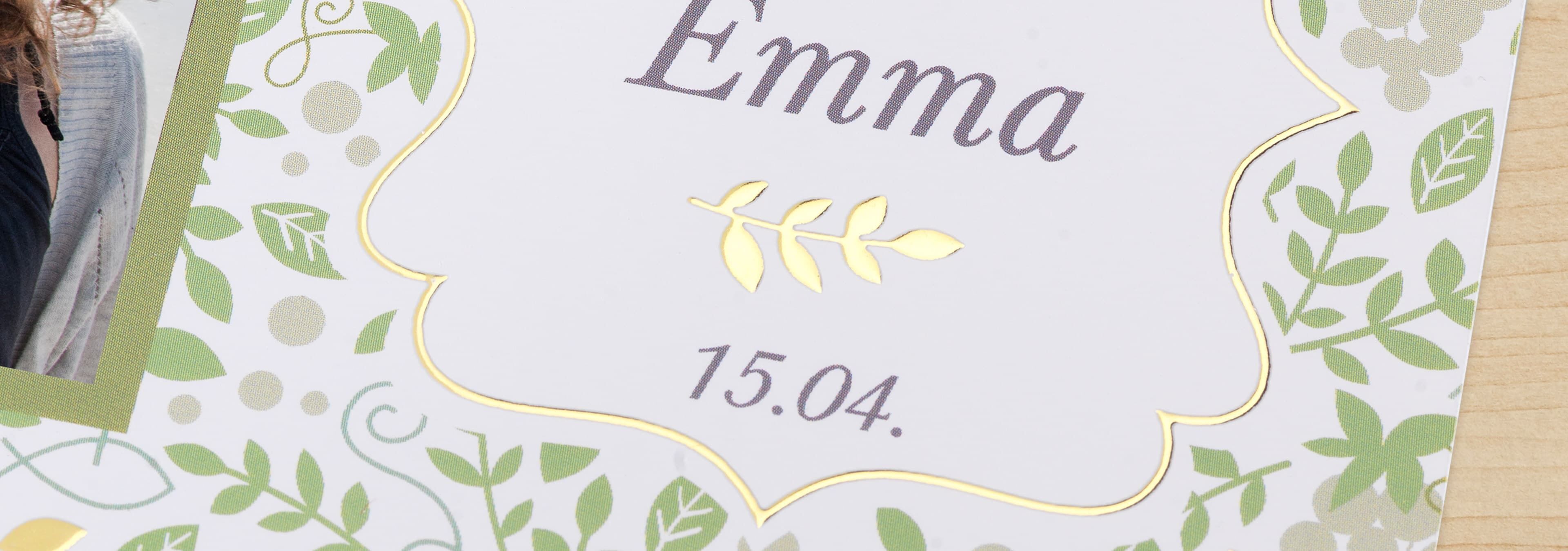Detaljeret fotoprint med navnet "Emma" i gylden skrifttype omkranset af grønne blade.