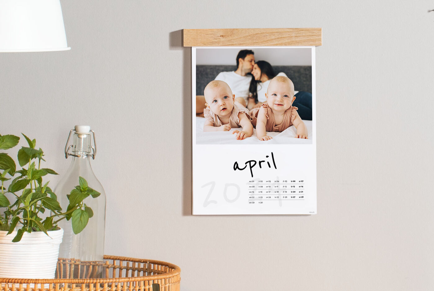 En inspirerende vægkalender med et billede af lykkelige mennesker og et kalenderblad for april.