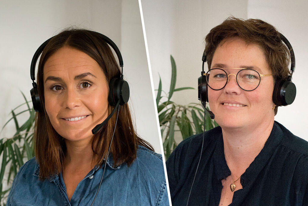 To personer med headset i et moderne kontor, de smiler.