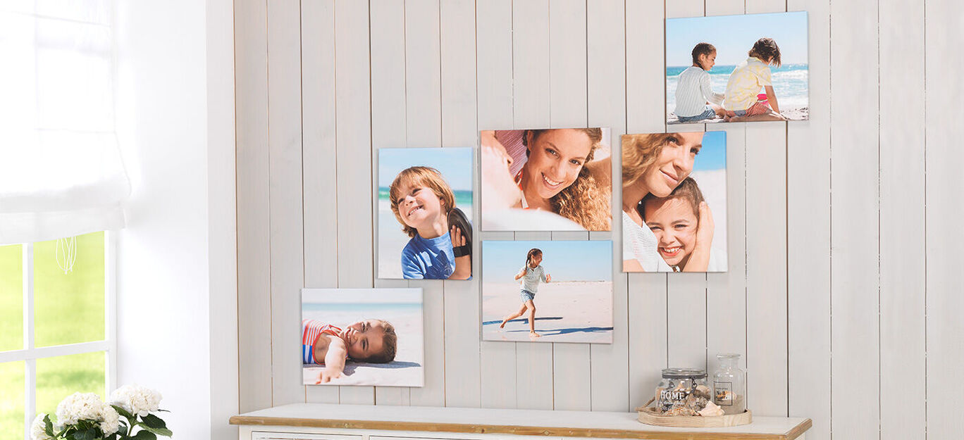 Stemningsfuld vægdesign med familie fotos på hylde i træ.