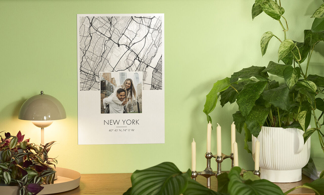 Et plakat fra New York hænger på en grøn væg. Det viser et scenebillede og teksten "NEW YORK".