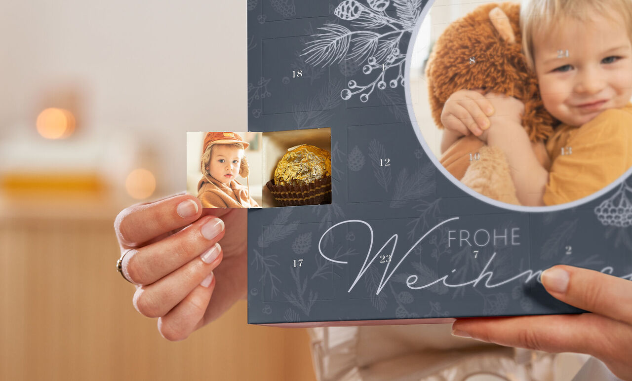 En person holder et julealbum med et lille foto og et billede af en gylden muffin