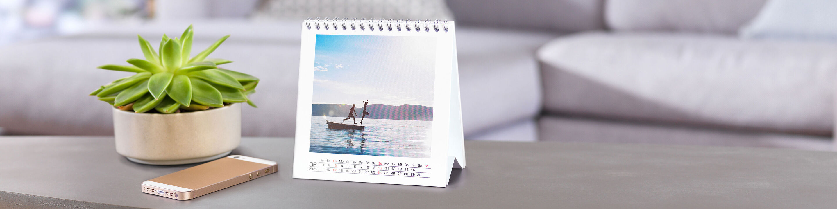 Vidunderligt bord med en CEWE fotokalender og en plante