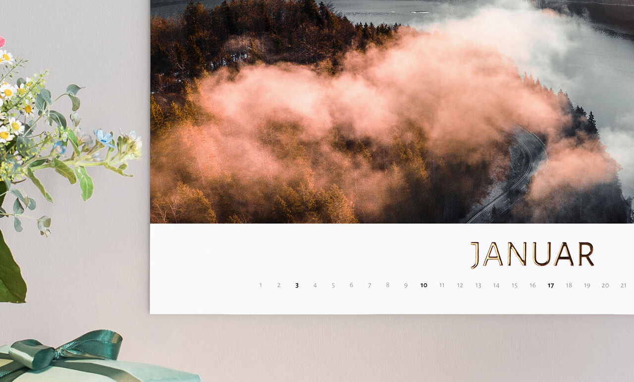 Kalenderblad for januar med let tåge over en skovlandsby